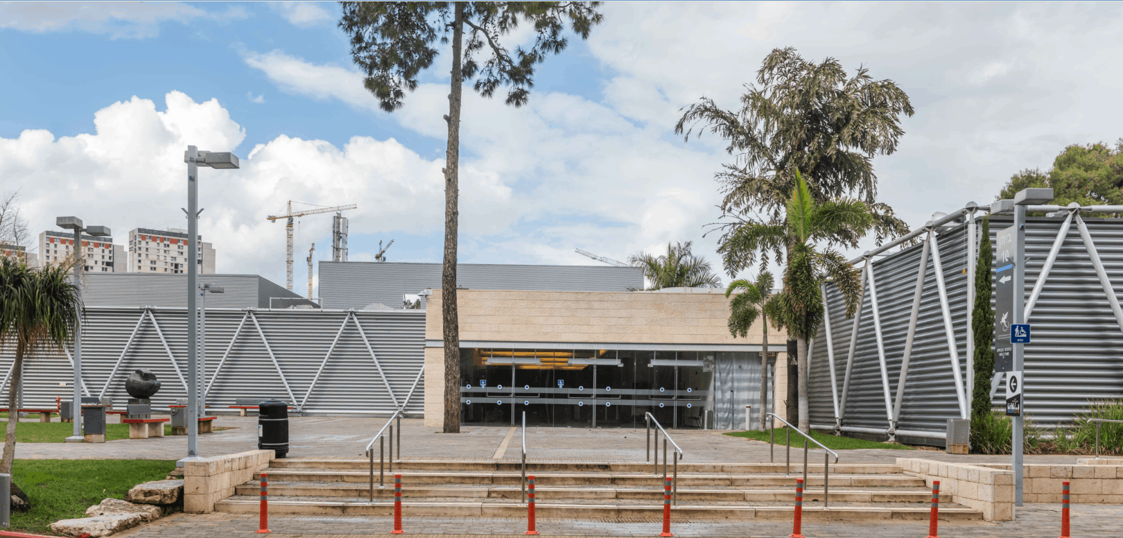 צילום של חזית ביתן 10 המחודש באקספו תל אביב, לאחר שעבר שיפוץ מקיף. המבנה מציג עיצוב מודרני המשלב חיפויי מתכת וזכוכית, עם רחבת כניסה ומדרגות אבן בחזיתו.